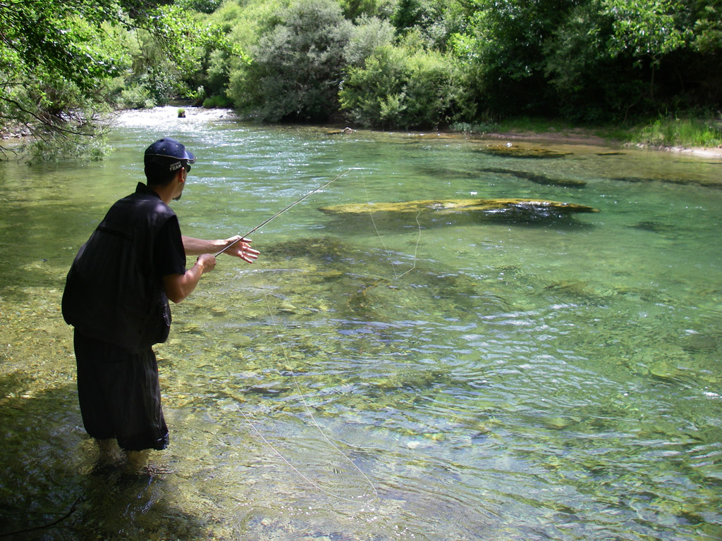 pêcheur à la mouche dans une petite rivière des cévennes aux eaux limpides
